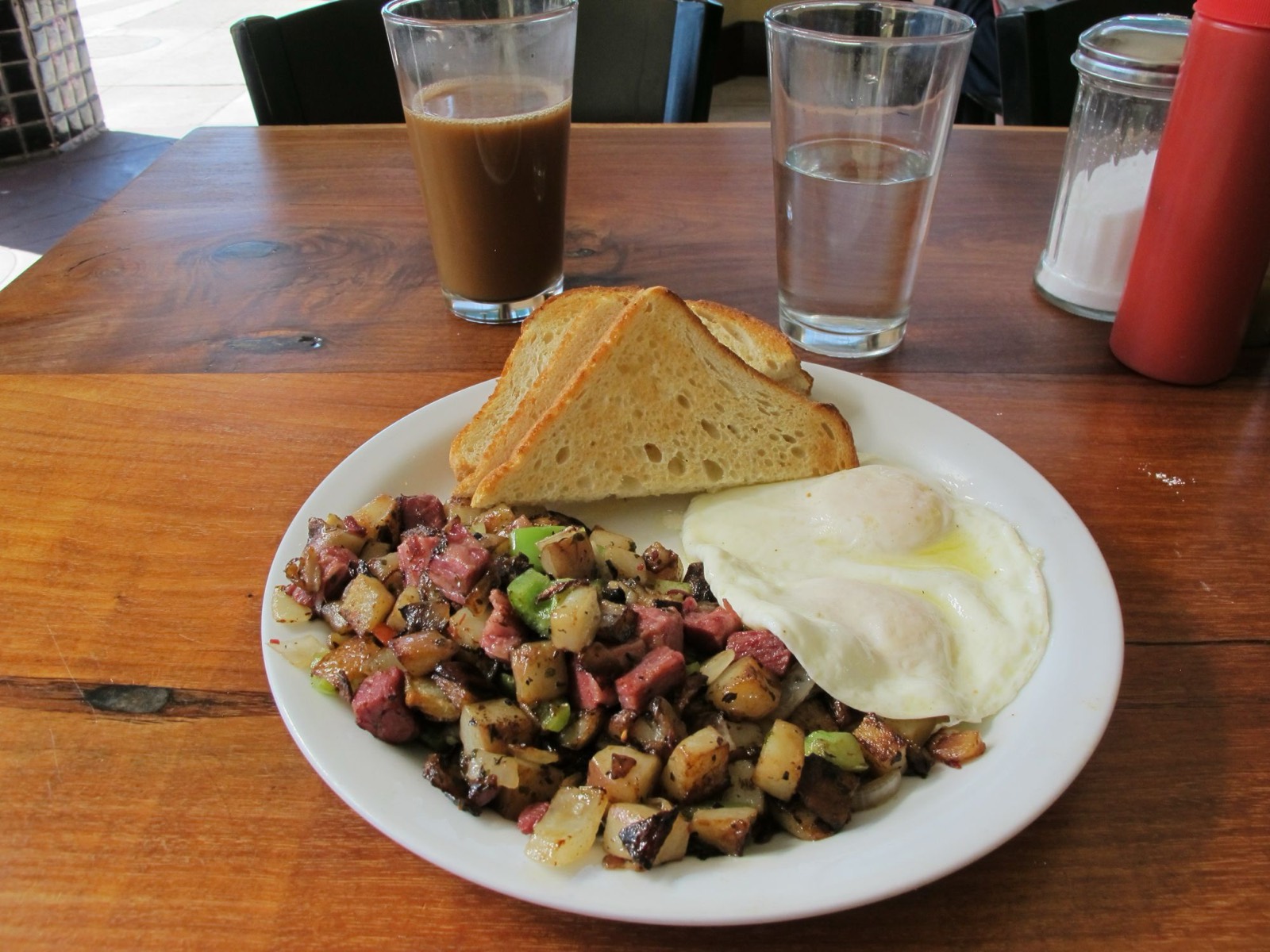 Corned beef hash breakfast with two eggs and toast